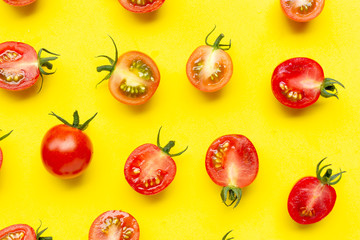 Fresh tomatoes, whole and half cut isolated on yellow background.
