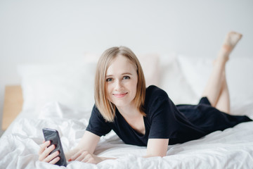 Portrait young mom women uses smart phone for Internet and online chat. Career leave concept, freelance