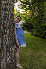 Fototapeta premium Husband set his head to his pregnant wife, hiding behind a tree, a funny prank