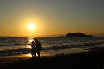 夕暮れの海辺の二人