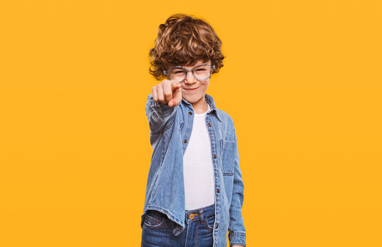 Stylish kid pointing with forefinger at camera