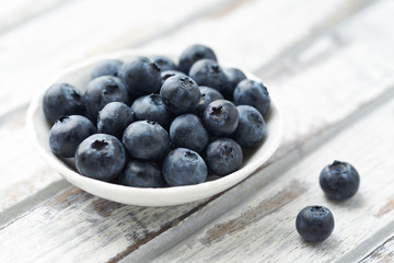 Bilberries on bright wooden background. Concept for healthy nutrition. 
