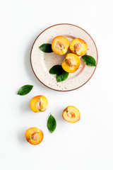 Healthy food. Ripe sliced peaches on plate on white table top-down