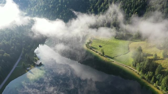 Flight over forest with early morning fog, lake Ferchensee, Bavaria