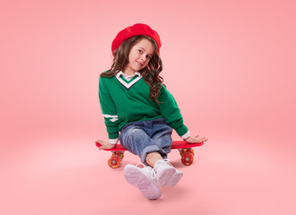Trendy child sitting on skateboard