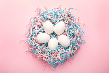 Easter creative composition. Flat lay with easter egg and kraft paper pink and blue filler on pink...