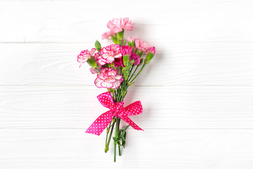 bouquet of different pink carnation flowers on white wooden background Top view Flat lay Holiday card 8 March, Happy Valentine's day, Mother's day concept