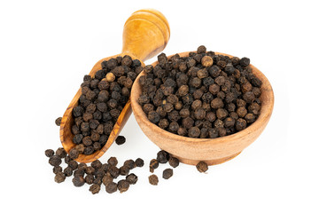 A small wooden bowl and a wooden spice shovel with whole black peppercorns isolated in front of a white background