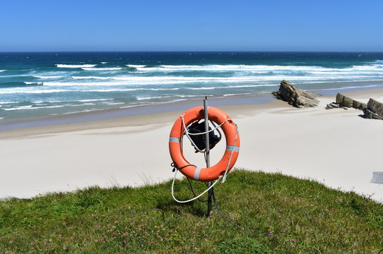 Beach with life saver, white sand and wild sea with waves on a sunny day. Viveiro, Lugo, Galicia, Spain.