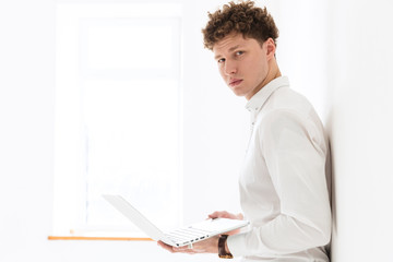 Fototapeta premium Handsome confident young curly haired businessman