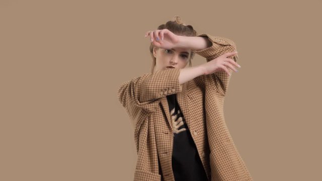 model wears an oversize vintage jacket in goose paws print and poses to the camera puts her hands in front of her face