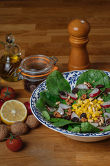 Ensalada de espinacas con nueces, rabanos, pasas y maiz. Dieta mediterranea vegetariana