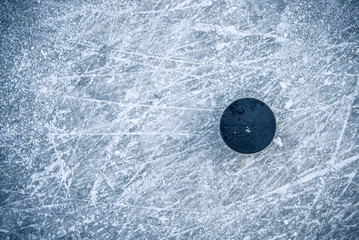 Fototapeta premium black hockey puck lies on ice at stadium