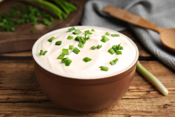 Fresh sour cream with onion on wooden table, closeup