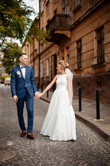 Fototapeta premium Bride and Groom on Wedding Day in city. Wedding couple after wedding ceremony.