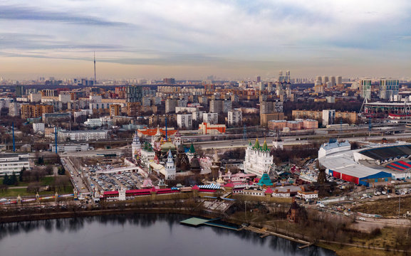 Aerial photo of the evening city of Moscow, in the frame of the Izmailovsky Kremlin, lake embankment and city buildings. In the background is the city and the streets.