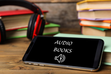 Modern smartphone and books on wooden table, closeup