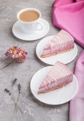 Homemade pink cheesecake with cup of coffee on a gray concrete background. side view.