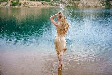 Beautiful slender girl with long hair posing standing in the water