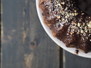 Festive homemade cakes. Round chocolate muffin, large muffin or cake with chocolate icing on a wooden ancient background.