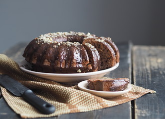 FestiveFestive homemade cakes. Round chocolate muffin, large muffin or cake with chocolate icing on a dark wooden background. Place for text.