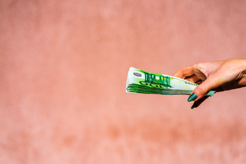 Hand holding showing euro money or giving money like bribe or tips.100 EURO banknotes EUR currency...