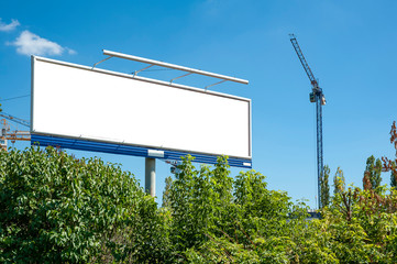 Huge blank white billboard for advertisement near construction site - obrazy, fototapety, plakaty