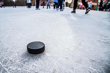 black hockey puck lies on ice at stadium