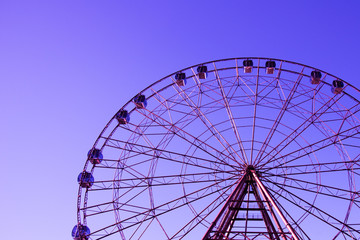 Fototapeta premium The outline of the Ferris wheel against the sky is a beautiful color.