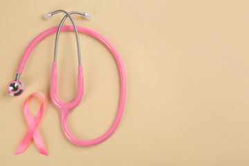 Pink ribbon and stethoscope on beige background, flat lay with space for text. Breast cancer concept
