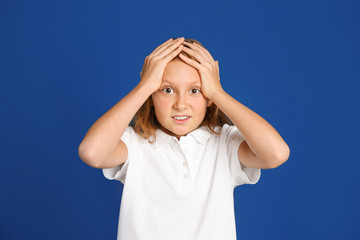 Portrait of emotional preteen girl on blue background
