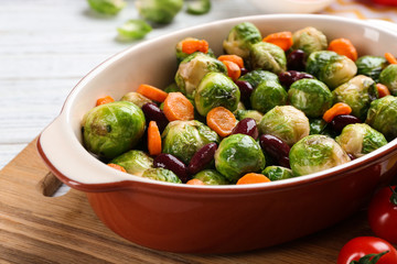 Roasted Brussels sprouts with beans and carrot in baking dish, closeup
