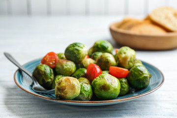 Roasted Brussels sprouts with cherry tomatoes on white wooden table