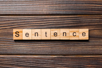 Sentence word written on wood block. Sentence text on table, concept