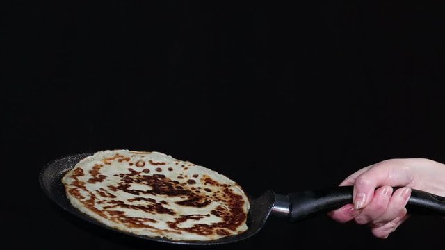 the cook tosses flips and catches a pancake in slow motion on a frying pan in an advertising Studio
