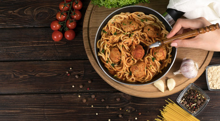 spaghetti and tomatoes on a wooden background