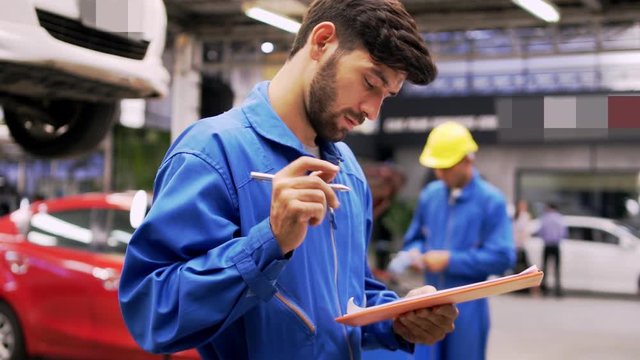 Man specialist an auto mechanic in a car service checks the machine diagnostics. with his team . 