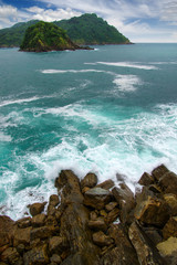 Ocean wave crashing on rock in the bay