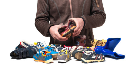 Hands are sorting out shoes and clothes from second hand