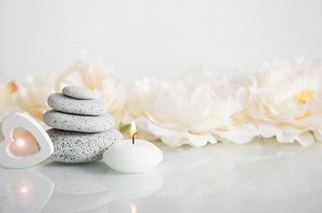 Minimalist balance zen stone beauty products background with wooden heart light, spa candle burning...