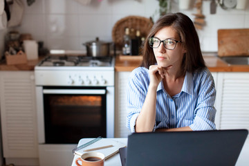 Young woman working from home office. Girl freelancer using laptop and the Internet. Workplace in...