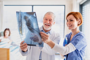 Doctors standing in hospital room, examining an X-ray.