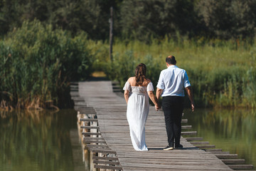 couple walking on bridge over river