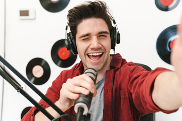 Image of young man at radio making podcast recording for online show