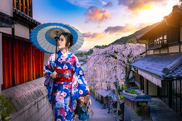 Young women in beautiful Japanese kimono dress enjoying Historic Higashiyama district, Kyoto in...