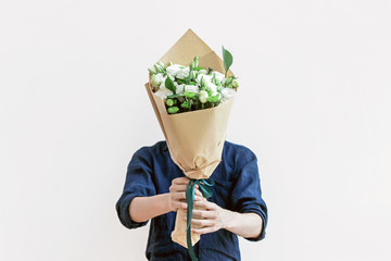 man in blue shirt  holding white flower bouquet
