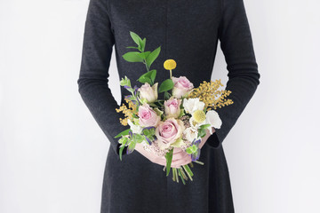 black dress woman florist holding colorful flower bouquet