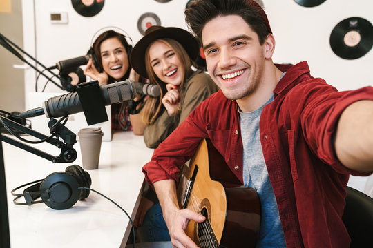 Image of young happy caucasian people performing at radio program