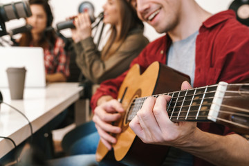 Fototapeta premium Image of young happy caucasian people performing at radio program