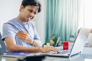 Young Asian office worker having chest pain , Overworked concept , office syndrome
